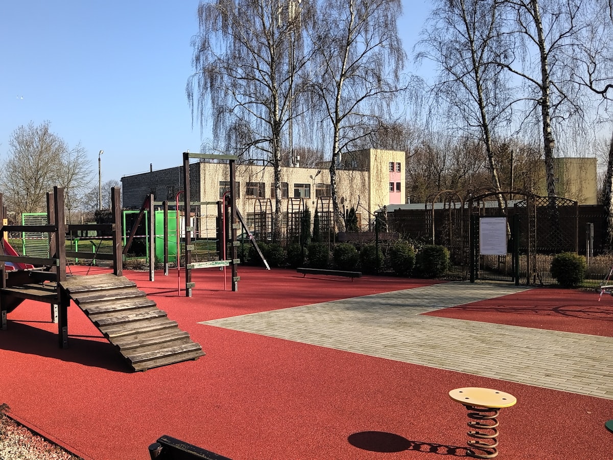 Playground equipment in front of a small neighborhood childcare building