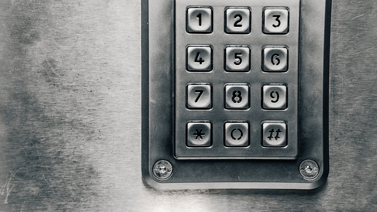 Close-up of a silver numeric keypad mounted on a scratched metal panel, used to enter a passcode instead of a physical key