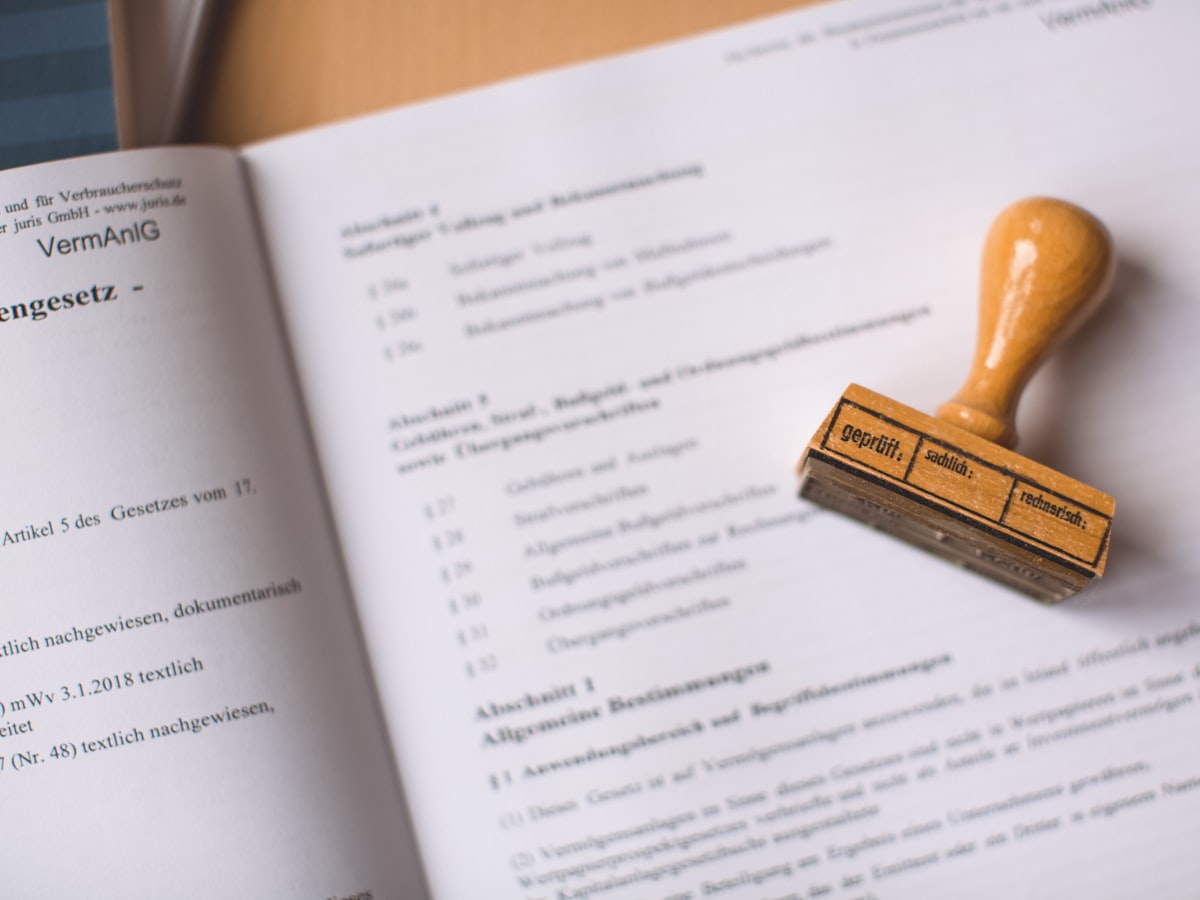An official rubber stamp resting on an open legal document, representing the bureaucratic registry process a Korean birth certificate still has to clear