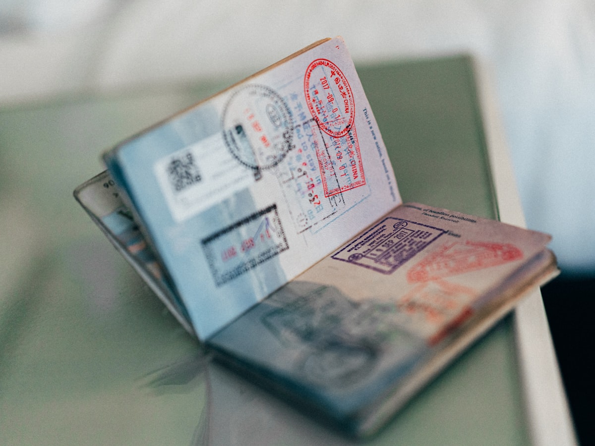 A passport lying open to pages filled with visa and entry stamps