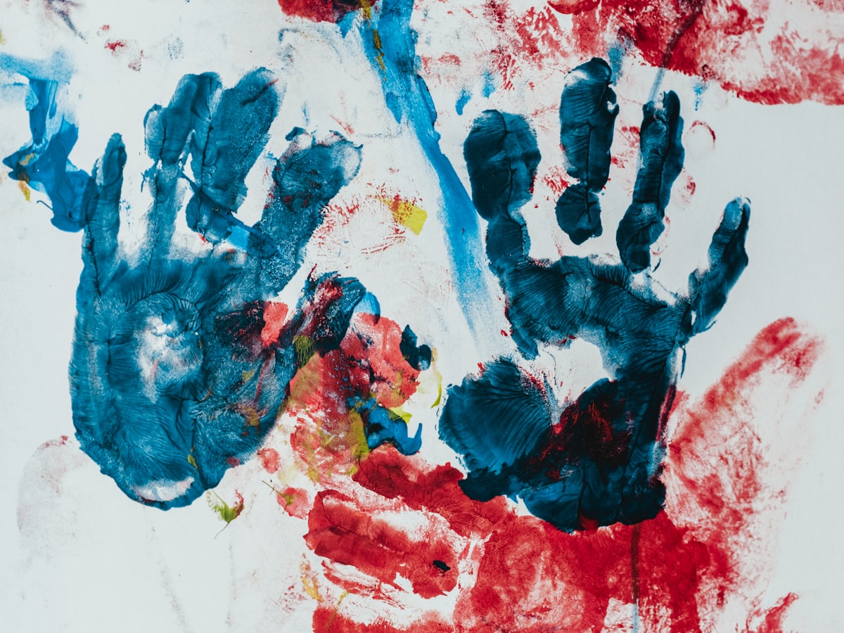 Colorful blue and red children's handprint paintings on paper
