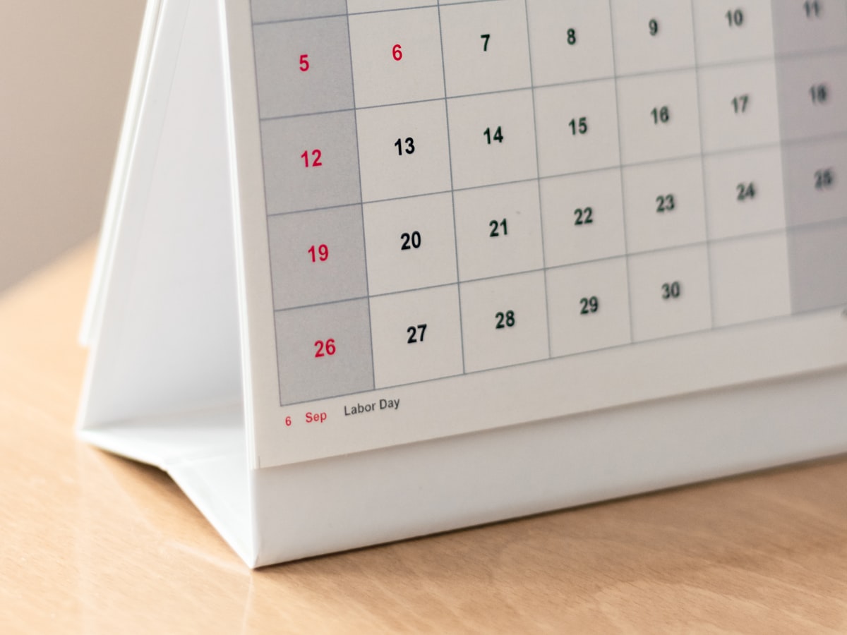 Close-up of a desk calendar page showing a September grid with weekend dates marked in red