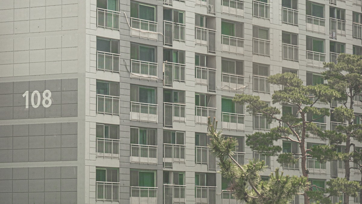 Exterior of a Korean apartment tower with the building number 108 painted on its side
