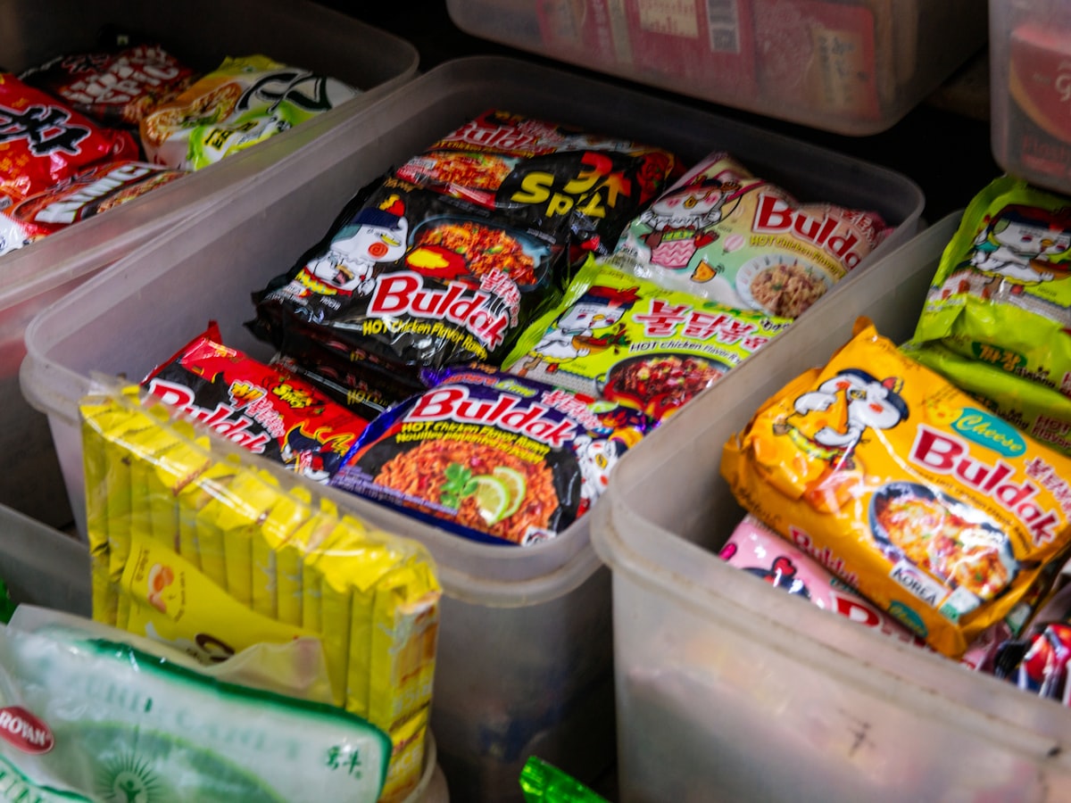 Individually wrapped instant noodle packs bundled together in bins at a Korean convenience store