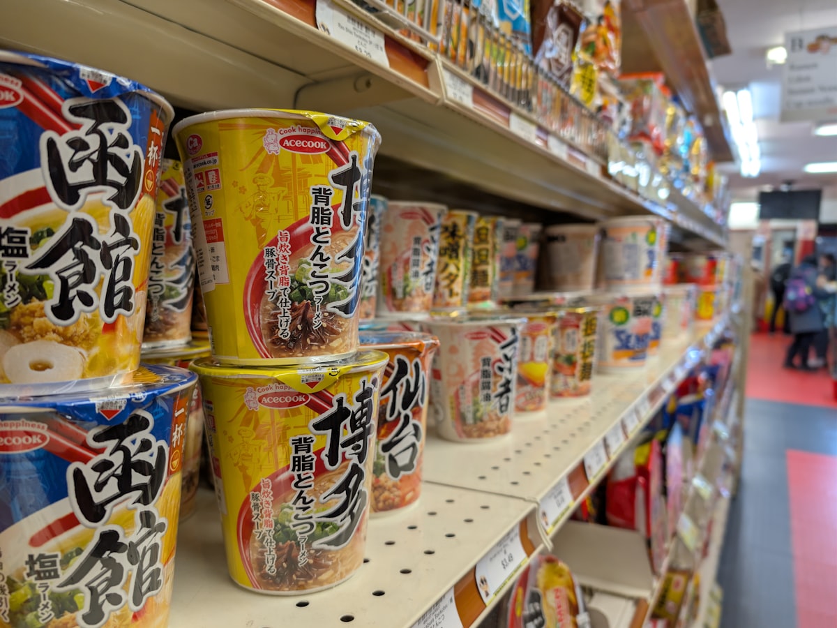 Close angled shelf of individual instant noodle cups on display
