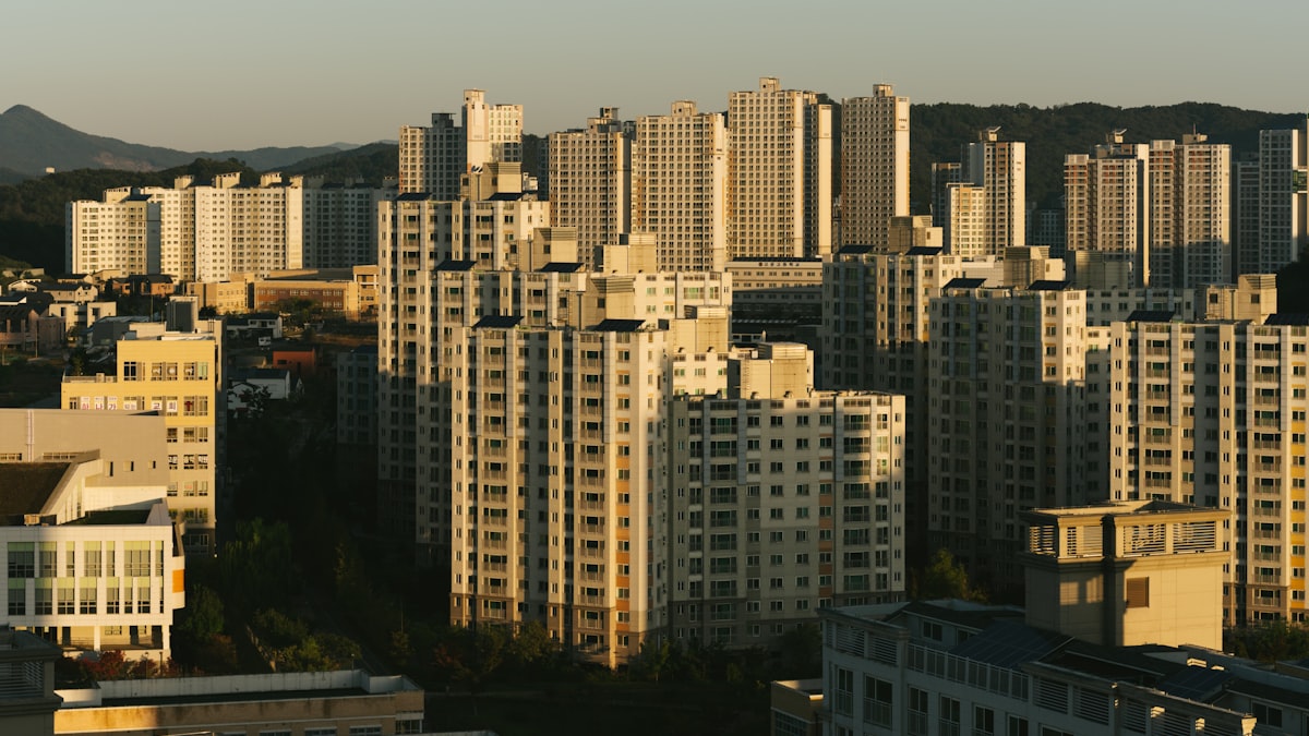 Korean apartment towers at sunset with mountains on the horizon