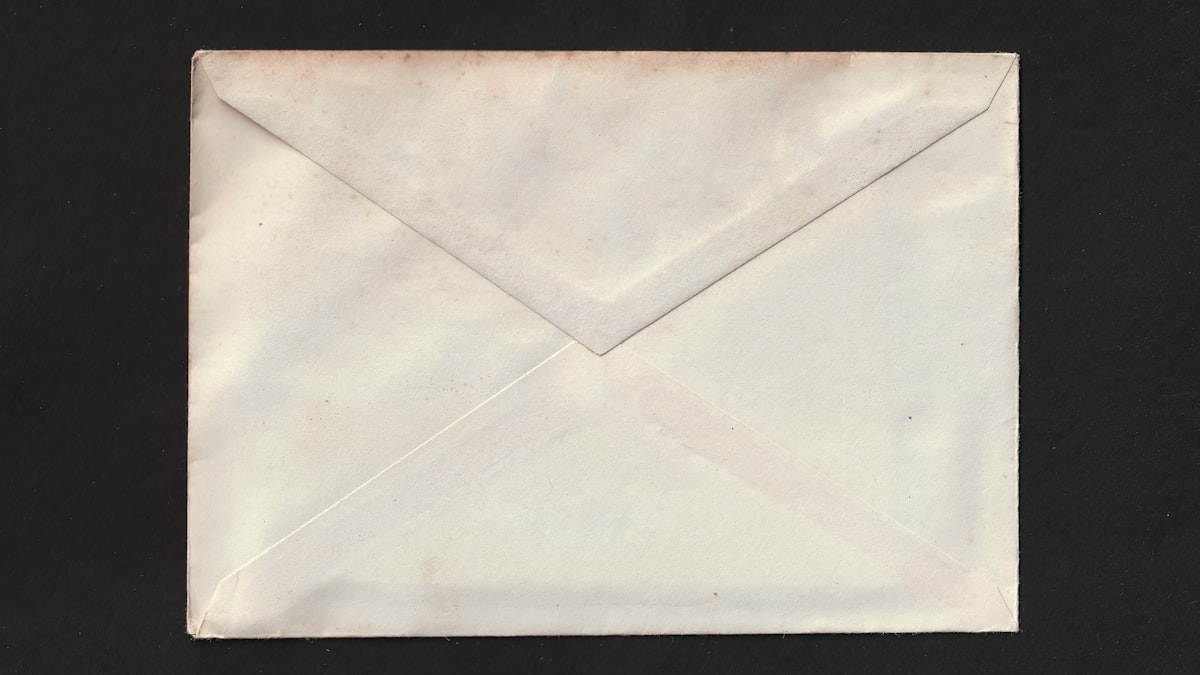 Plain white sealed envelope centred on a black background