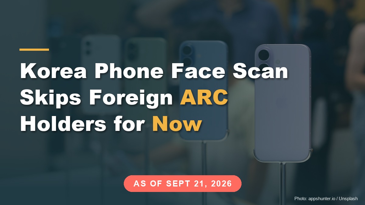Colored smartphones on display stands in a phone shop with blurred shoppers behind, under the title "Korea Phone Face Scan Skips Foreign ARC Holders for Now"