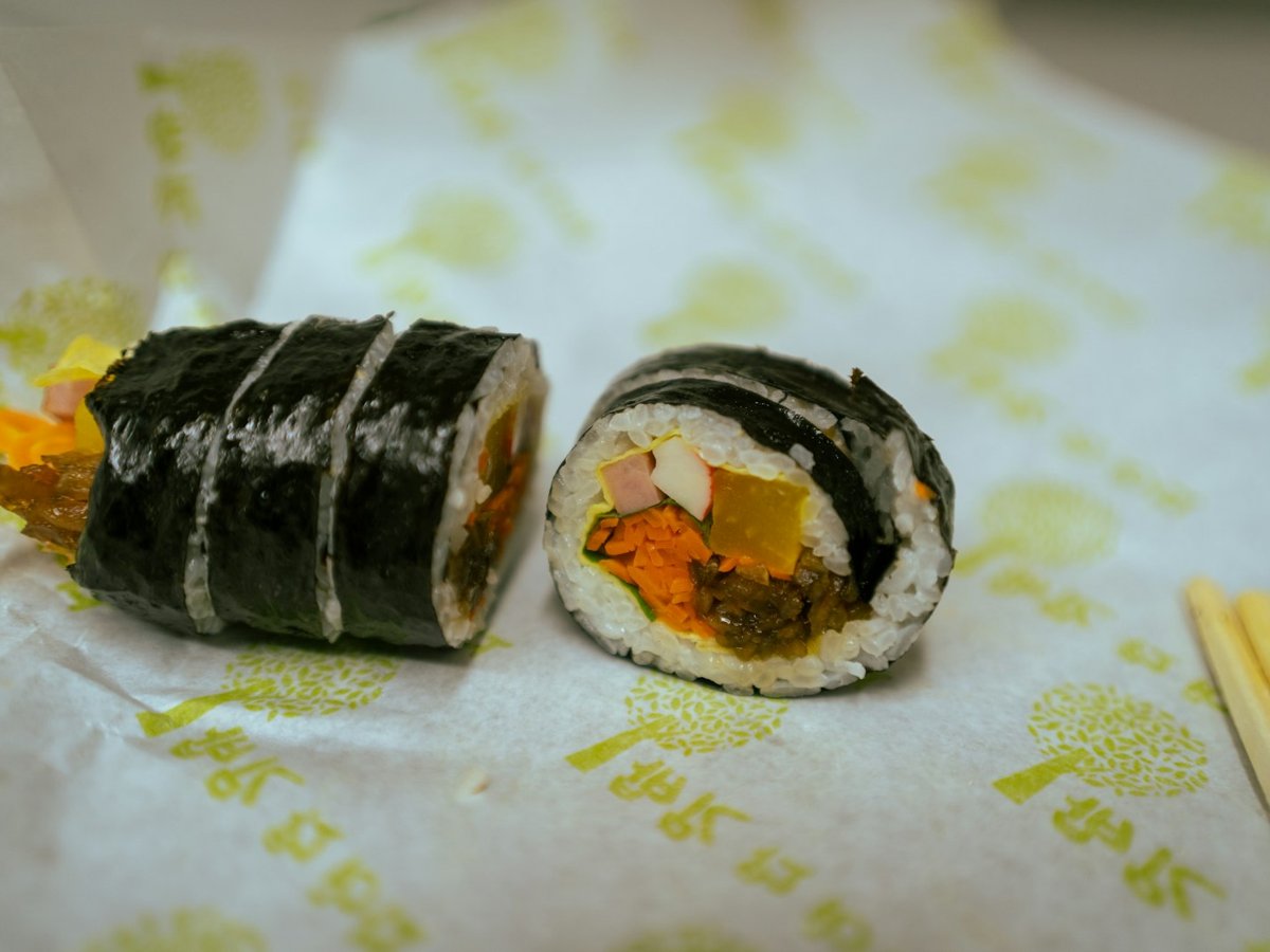 A sliced kimbap roll on paper wrapping at a Seoul snack bar
